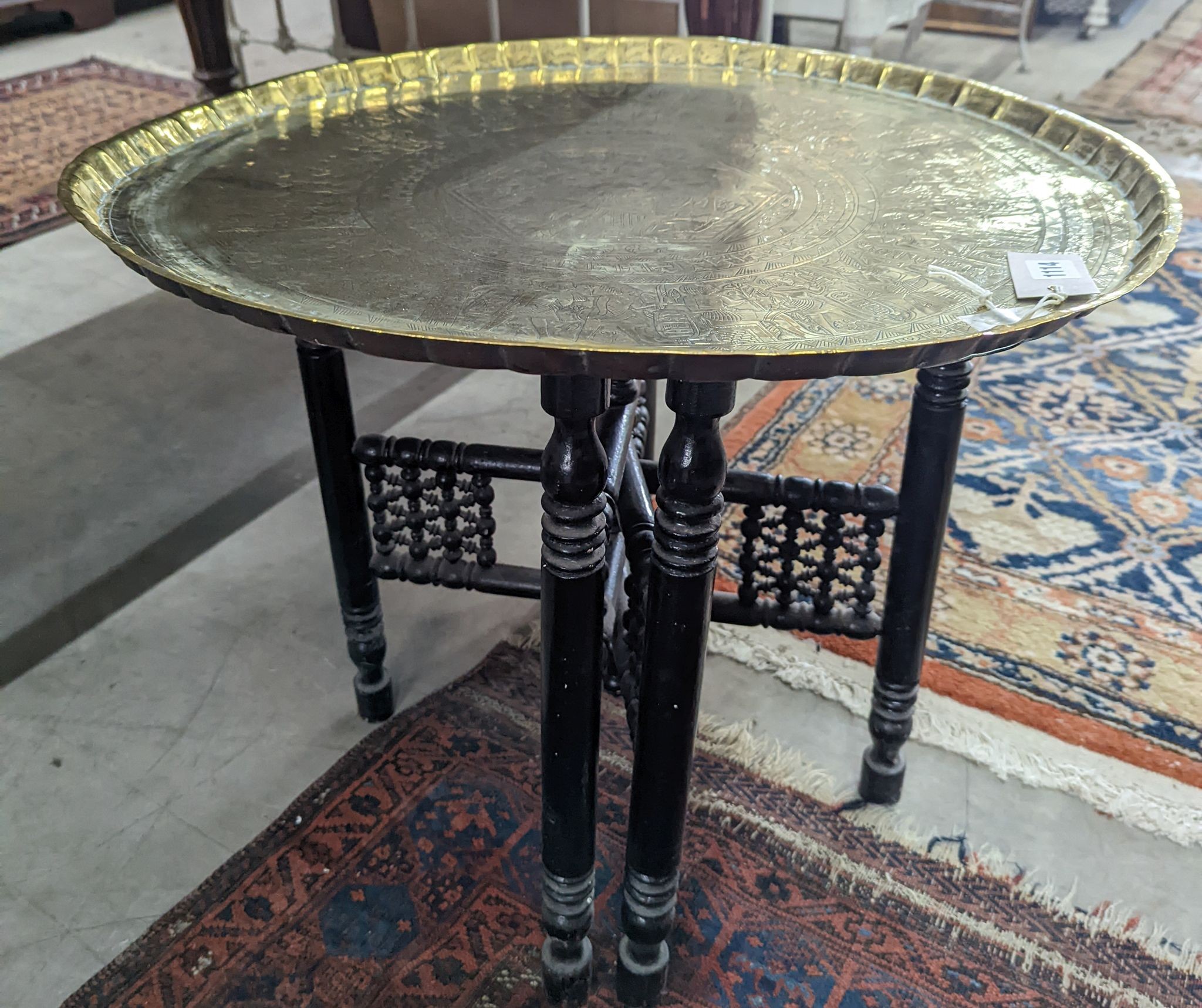 An Egyptian circular brass tray top occasional table, diameter 62cm, height 52cm